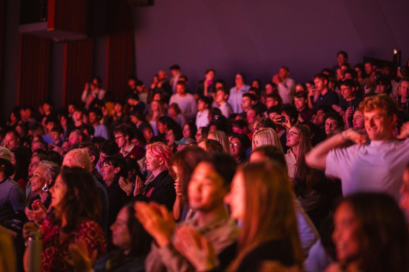 A packed audience laughing and clapping at the College vs Cancer show at USC